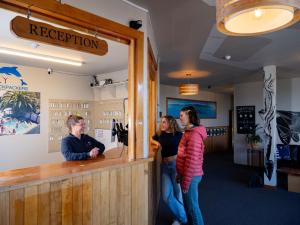 three people standing at a counter in a restaurant at Dusky Lodge in Kaikoura +74 photos