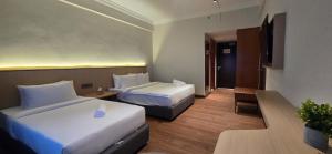 ein Hotelzimmer mit zwei Betten und einem Fernseher in der Unterkunft Kingston Hotel 28 - Gocos Hotel Klang in Klang + 39 Fotos