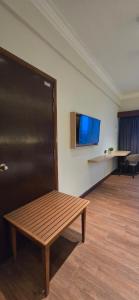 ein Zimmer mit einer Bank und einem Flachbildfernseher in der Unterkunft Kingston Hotel 28 - Gocos Hotel Klang in Klang