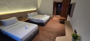 ein Hotelzimmer mit zwei Betten und einem Flur in der Unterkunft Kingston Hotel 28 - Gocos Hotel Klang in Klang