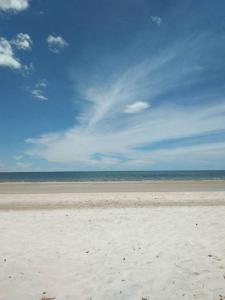 a sandy beach with the ocean in the background at THAMONWAN hostel in Cha Am
