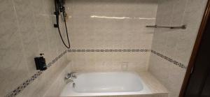 eine weiße Badewanne in einem Badezimmer mit Dusche in der Unterkunft Kingston Hotel 28 - Gocos Hotel Klang in Klang