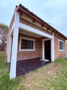 a brick house with a large open garage at Esquina Hostel in Esquina