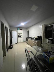 a large kitchen with a table and a refrigerator at Vieira House in Brasília