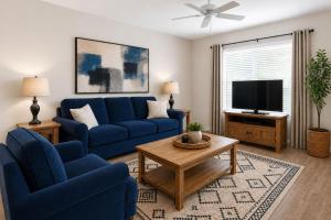 a living room with blue couches and a tv at First Tracks Cabin in Eden