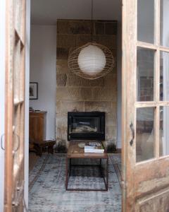 a living room with a fireplace and a table at Raffah House in Oatlands