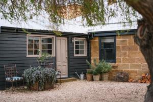 a black house with a door and some plants at Raffah House in Oatlands