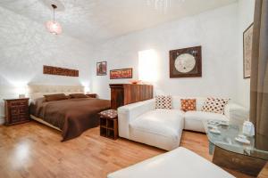 ein Schlafzimmer mit einem Bett und einem weißen Sofa in der Unterkunft Bishop Apartments in Brünn