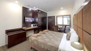 a bedroom with a bed and a sink and a microwave at Western Downs Motor Inn in Miles