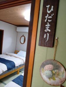 a bedroom with two bunk beds and a sign on the wall at ただいまtadaima in Yahata