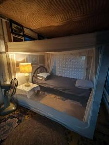 a small bedroom with a bunk bed with a lamp at Slove U House in Khon Kaen