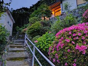 a set of stairs leading up to a house with flowers at ただいまtadaima in Yahata