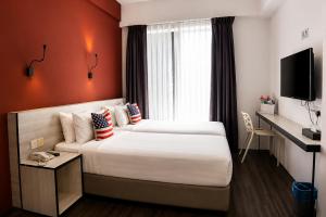 a hotel room with two beds and a television at Manhattan Hotel Ipoh in Ipoh