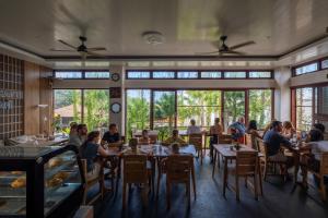 a group of people sitting at tables in a restaurant at Bali Residence Villa in Uluwatu