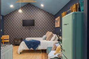 a bedroom with a bed and a tv on a wall at Soft Launch Deal Butterfly Bungalow Studio in Saugerties