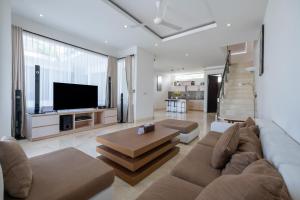 a living room with a couch and a tv at Bali Residence Villa in Uluwatu
