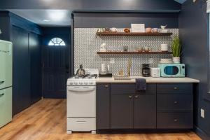a kitchen with blue walls and a white stove top oven at Soft Launch Deal Butterfly Bungalow Studio in Saugerties