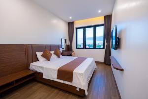 a bedroom with a bed and a large window at LunaB Hotel in Dong Hoi +6 photos