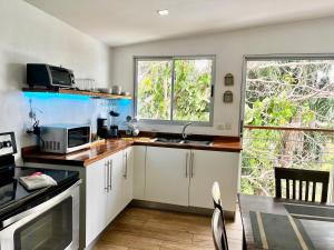 a kitchen with white cabinets and a table and a window at Casa Roraima in San Antonio
