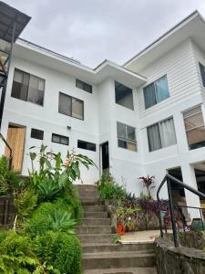 a white house with stairs and plants at Casa Roraima in San Antonio