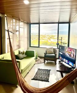 a hammock in a living room with a couch and a tv at Casa Roraima in San Antonio