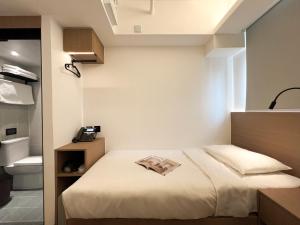 a bedroom with a bed with a book on it at Bridal Tea House Hotel - Yaumatei in Hong Kong