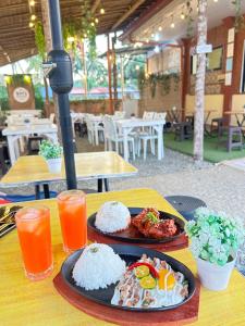 a table with two plates of food and orange juice at RM's Tourist Inn in Carmen