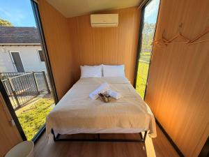 a bed in a room with a large window at Tiny Home in the Hills by Tiny Away in Perth