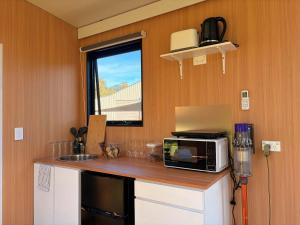a kitchen with a counter with a microwave and a sink at Tiny Home in the Hills by Tiny Away in Perth