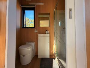 a bathroom with a toilet and a glass shower at Tiny Home in the Hills by Tiny Away in Perth