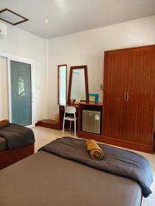a bedroom with a bed and a dresser and a mirror at Ban Tai Resort in Ban Tai +43 photos