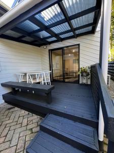 a porch with a bench and a table on it at 2 Bedroom Comfortable Guest Wing in Hamilton
