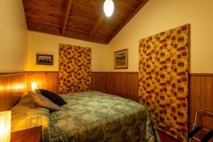 a bedroom with a bed and a wooden wall at Falls Lodge - a Blue Mountains experience in Wentworth Falls