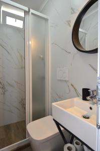 a white bathroom with a sink and a shower at Harmony Villa in Costinesti