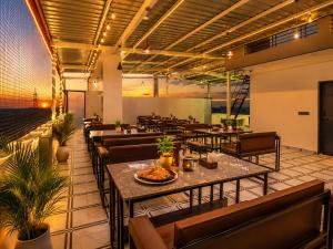 a restaurant with tables and chairs in a room at Hotel Starlink By The Nine Hotel in Jaipur