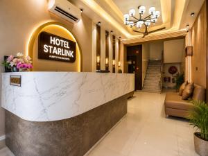 a hotel lobby with a reception counter and a hotel stinking sign at Hotel Starlink By The Nine Hotel in Jaipur