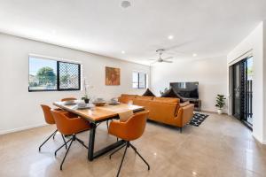 a living room with a table and a couch at 3BR Top Floor Apartment with Parking, EV friendly & Views Brisbane South in Brisbane