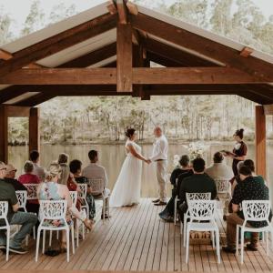 a bride and groom holding hands while standing on a deck at Tuckers Lane Boutique Accommodation in Rothbury +107 photos