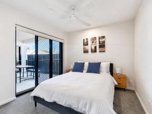 a bedroom with a large bed and a balcony at 3BR Top Floor Apartment with Parking, EV friendly & Views Brisbane South in Brisbane