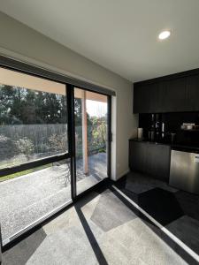 a kitchen with large sliding glass doors and a large window at 2 Bedroom Comfortable Guest Wing in Hamilton +11 photos