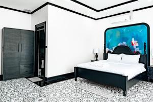 a bedroom with a bed with an aquarium on the wall at La Resident Indochina Hotel in Vientiane