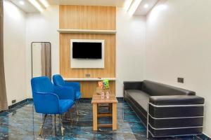 a living room with a couch and two blue chairs at Hotel Starlink By The Nine Hotel in Jaipur
