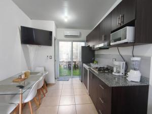 a kitchen with black cabinets and a counter top at Hermosa casa con piscina in Sitio del Niño