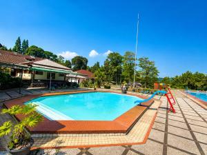 a swimming pool with a slide next to a building at Megamendung Hotel & Resort in Ciguntur