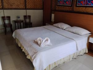 a bed with a white towel on top of it at Megamendung Hotel & Resort in Ciguntur