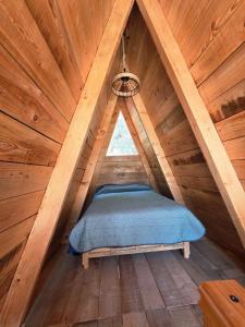 a bed in a wooden attic room with a window at Chalet Niquel in Mineral del Chico
