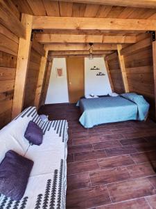 two beds in a room with wooden ceilings at Chalet Niquel in Mineral del Chico +8 photos