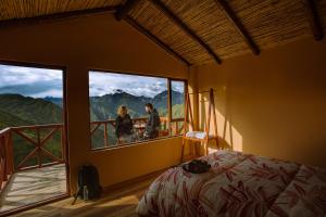 a couple standing in a bedroom with a window at Mountain View Lodge & Experience in Cusco
