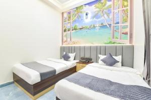 two beds in a room with a painting of a beach at Hotel Starlink By The Nine Hotel in Jaipur +18 photos