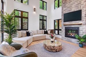 a living room with a couch and a fireplace at Alta Vita Ste-Adèle Modern, Forest, Spa and Sauna in Sainte-Adèle